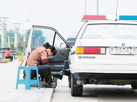 網(wǎng)曝警車中男子伸腳讓街邊婦女為其擦鞋(圖)
