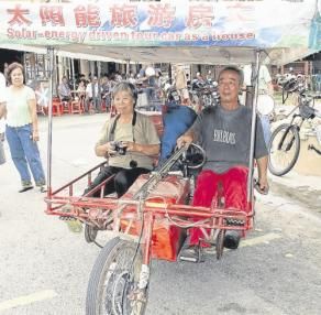 趙雅范(左起)及李林祥的太陽能三輪車吸引眾人的目光