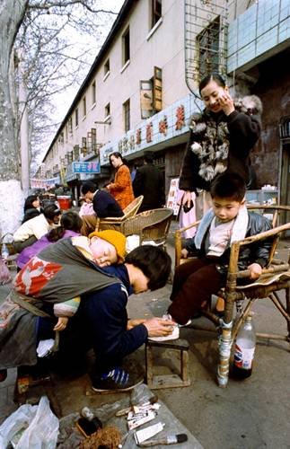 “窮母親背著孩子給富孩子擦鞋”(資料圖片)